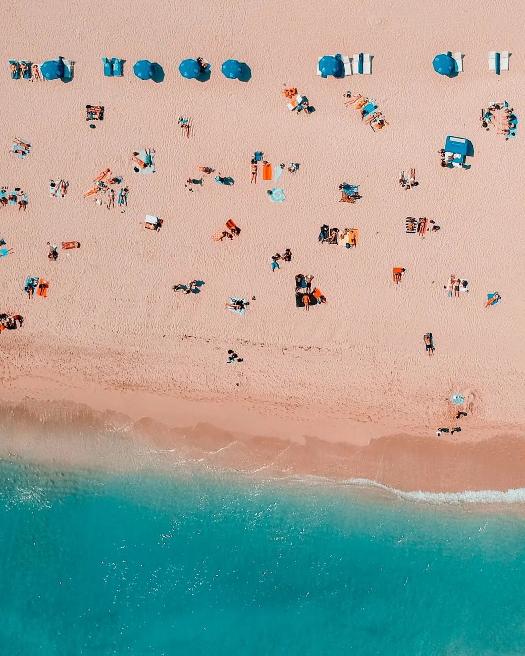 Areia rosada e mar azul vistos de cima